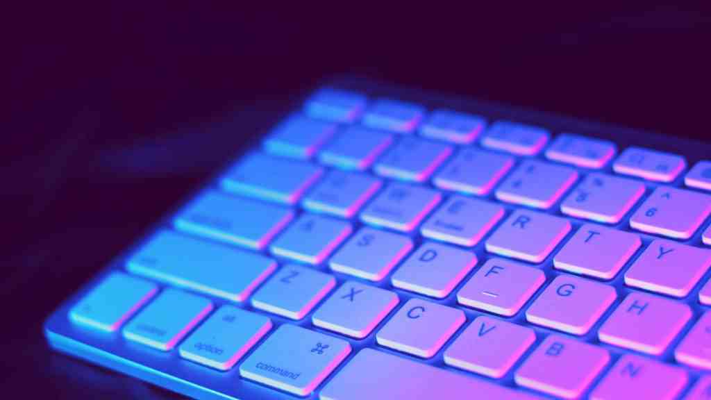 Neon-lit computer keyboard with colorful backlit keys, representing technology and coding, ideal for SEO content related to programming, web development, or tech innovations.
